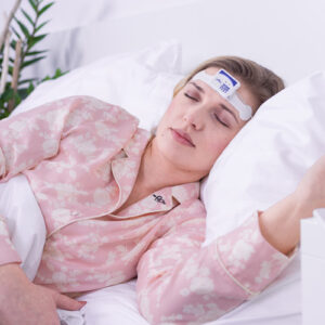 Schlafende Frau im Bett mit Home Sleep Test